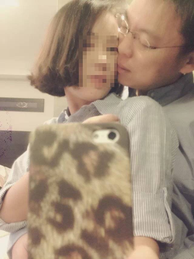 女子拿著手機對鏡子自拍,趙天麟親吻她臉頰,動作及神情都十分親密。(讀者提供)